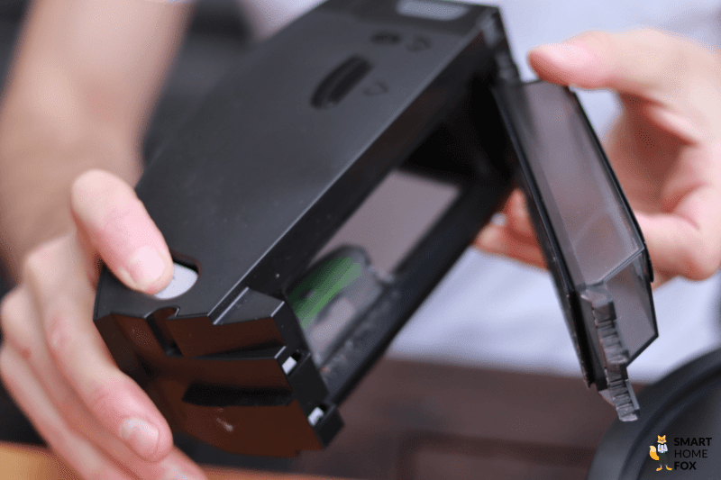 Der mobile Schmutzbehaelter eines iRobot Roomba Saugroboters wird in der Hand gehalten